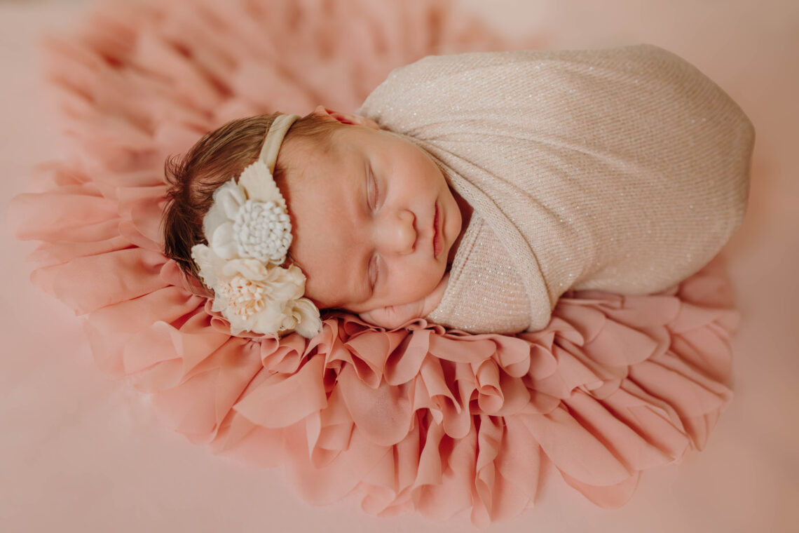 newborn girl in pink swaddle