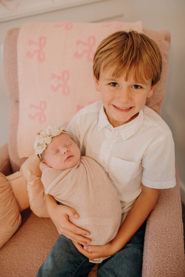 big brother holding newborn sister