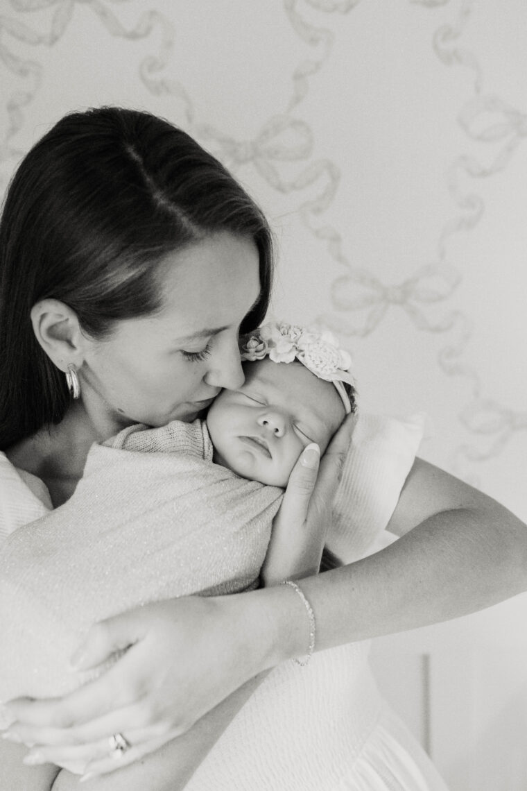 mother kissing newborn baby girl